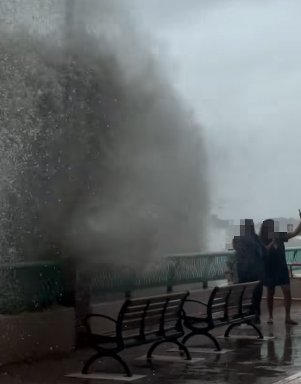 颱風樺加沙|鴨脷洲海怡半島岸邊,風暴時有兩名女子帶一名男童追風自拍時被巨浪沖跌(影片截圖)