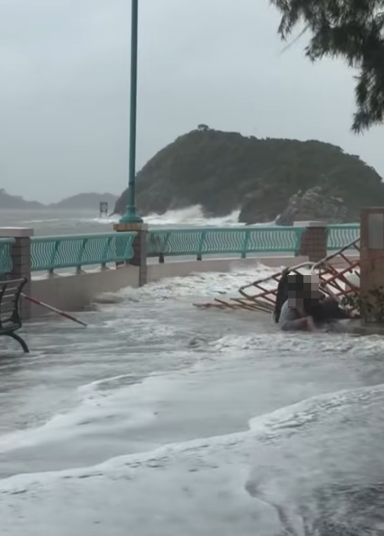 颱風樺加沙|鴨脷洲海怡半島岸邊,風暴時有兩名女子帶一名男童追風自拍時被巨浪沖跌(影片截圖)