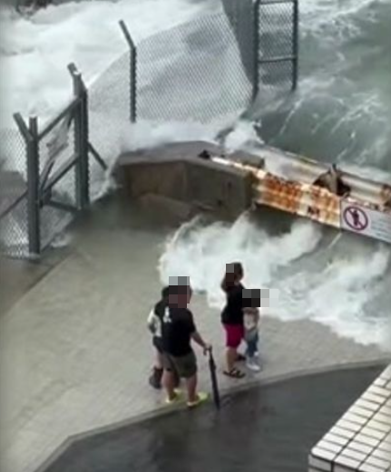 警拘捕一名46歲父親,及一名33歲印尼籍女傭,涉嫌於樺加沙襲港期間,帶同兩名分別4歲及6歲男童到堅尼地城海旁觀浪。(影片截圖)