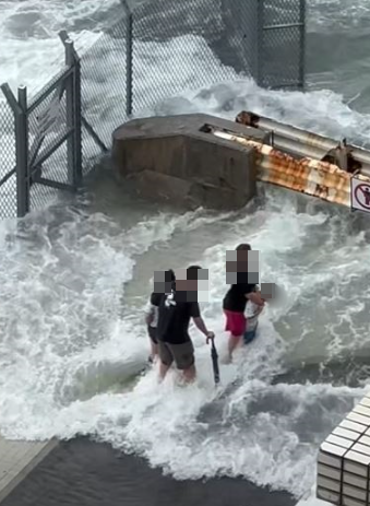 警拘捕一名46歲父親,及一名33歲印尼籍女傭,涉嫌於樺加沙襲港期間,帶同兩名分別4歲及6歲男童到堅尼地城海旁觀浪。(影片截圖)