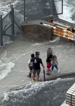 警拘捕一名46歲父親,及一名33歲印尼籍女傭,涉嫌於樺加沙襲港期間,帶同兩名分別4歲及6歲男童到堅尼地城海旁觀浪。(影片截圖)