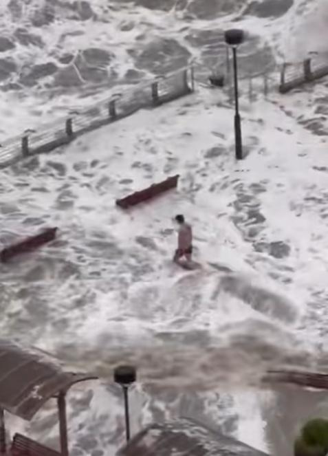 一名男子在海濱長廊觀景台,站立於水中,並迎浪撲面。(FB/將軍澳主場)