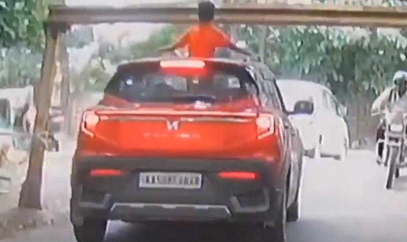 一名男童雙手撐住車頂,整個上半身都探出天窗外。(X)