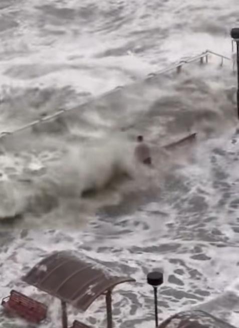 一名男子在海濱長廊觀景台,站立於水中,並迎浪撲面。(FB/將軍澳主場)