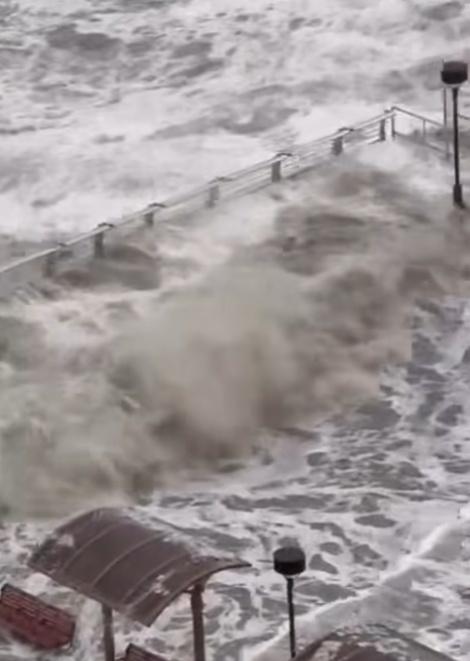 一名男子在海濱長廊觀景台,站立於水中,並迎浪撲面。(FB/將軍澳主場)