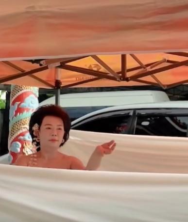 Amarat擺出多個優美動作進行裸舞儀式,她的四周拉上白布遮擋身體,但香肩清淅可見。(FB)