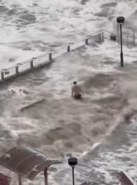 一名男子在海濱長廊觀景台,站立於水中,並迎浪撲面。(FB/將軍澳主場)