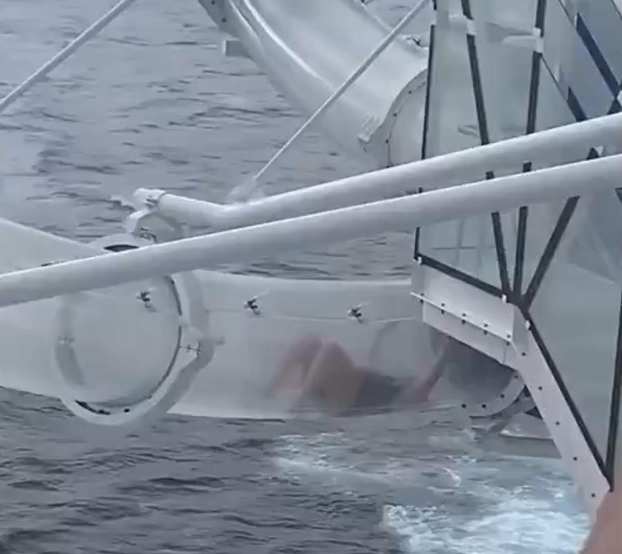 女子緊抓透明管壁不住扭動身體掙扎,卻無法前進。(X)