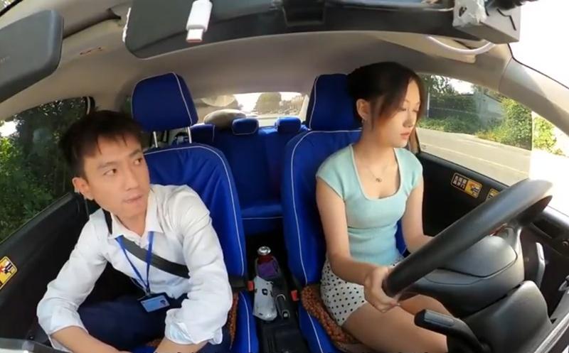 男考官坐在副駕駛座上,時不時將視線移向她的胸口位置。(微博)