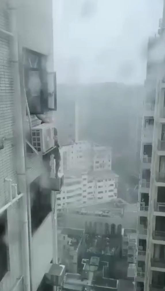 一名冷氣工疑在打風期間赤站危站高樓外牆維修。(網片截圖)