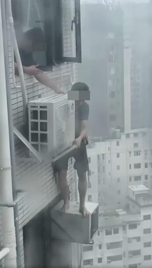 一名冷氣工疑在打風期間赤站危站高樓外牆維修。(網片截圖)