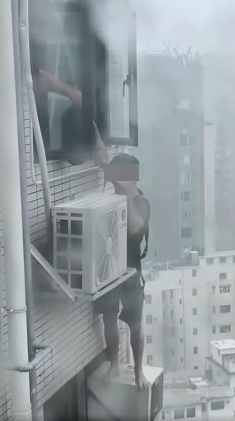 一名冷氣工疑在打風期間赤站危站高樓外牆維修。(網片截圖)