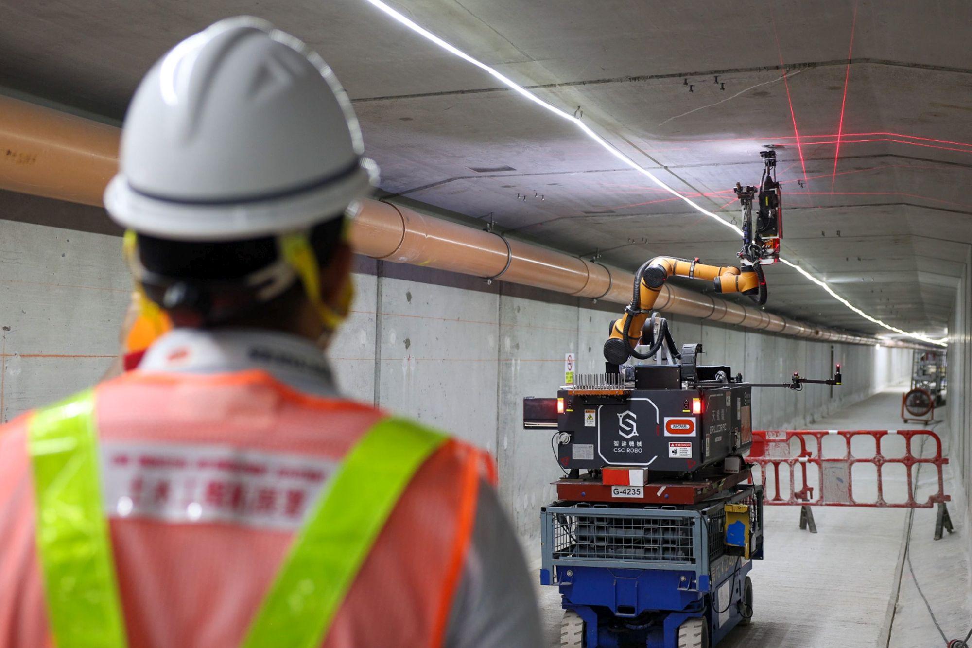 鑽孔機械人利用激光掃描技術確定好位置,並於隧道內的牆身及天花準確地鑽孔及裝上繫穩螺絲,同時會吸走過程中產生的粉塵,不僅提升工人職業安全健康水平,亦節省時間和人力成本。