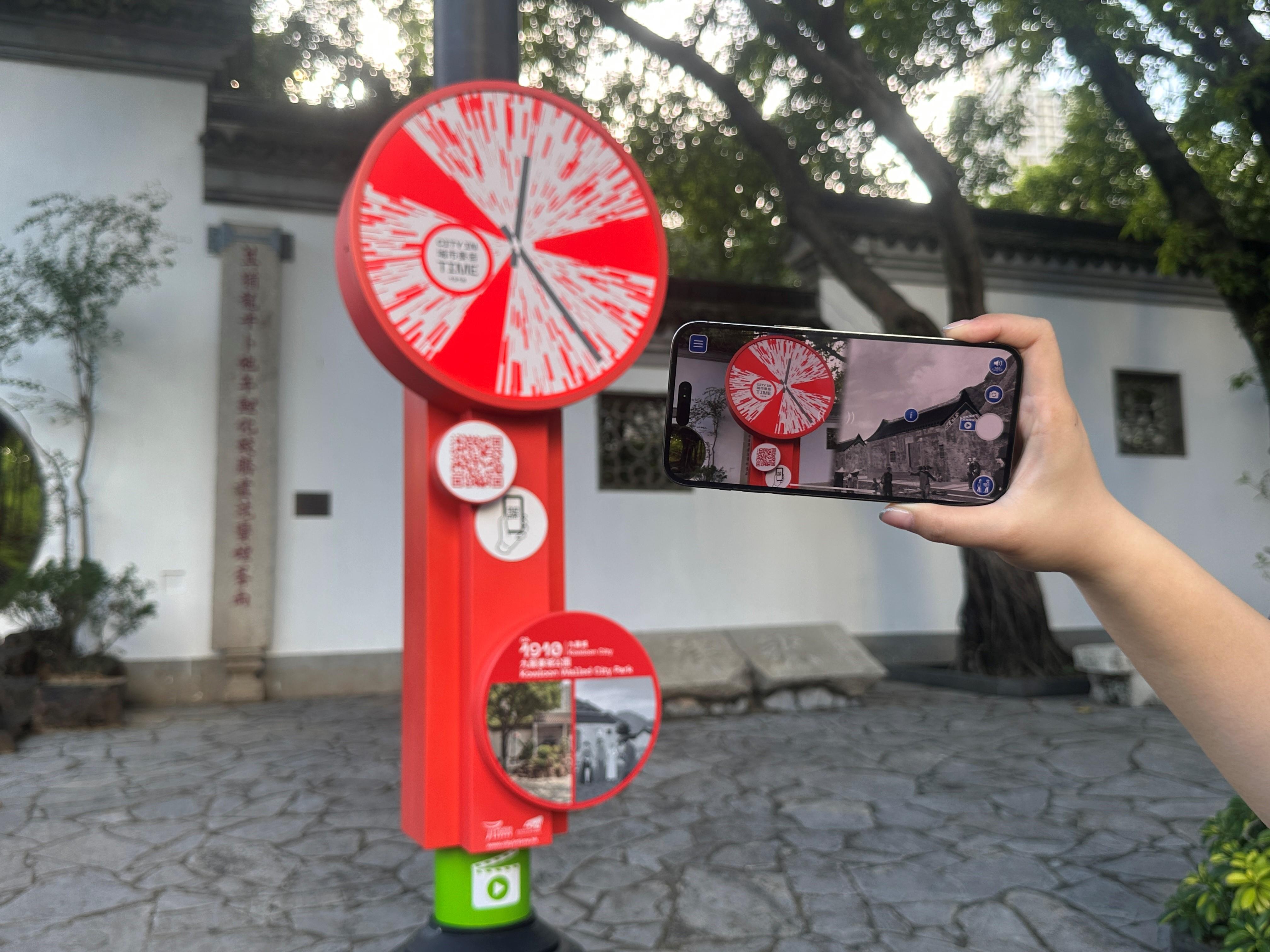 遊客在九龍寨城公園利用智能手機體驗「城市景昔」應用程式。(政府新聞處)