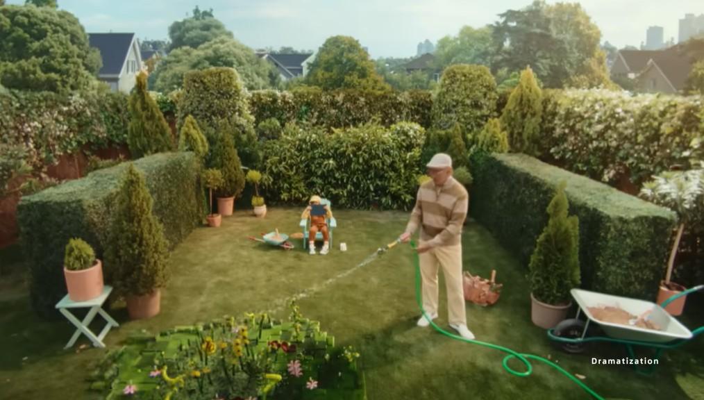 孫仔在花園陪著他淋花。