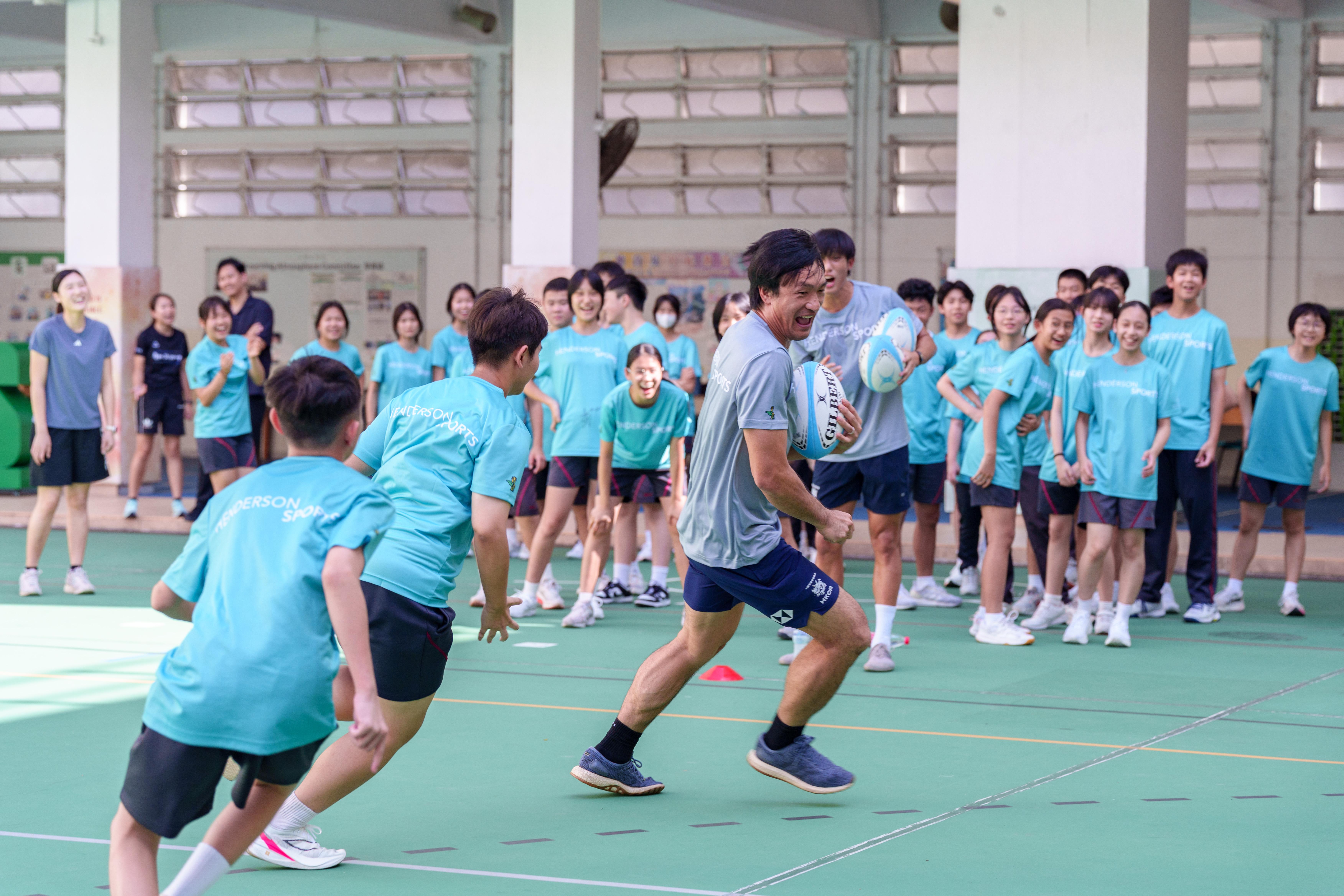 姚錦成親自落場教授120位學生打欖球。