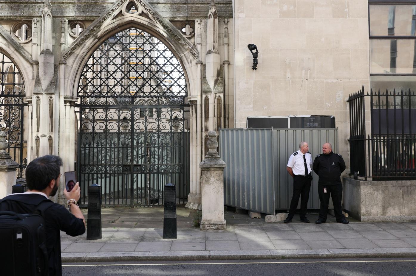 Banksy作品曝光後不久,保安員用圍欄遮住並在場駐守,有人離遠拍攝。(路透社)