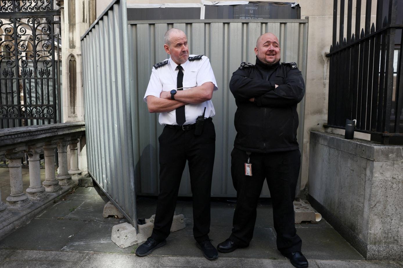 Banksy作品曝光後不久,保安員用圍欄遮住並在場駐守。(路透社)