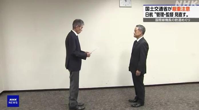 中川由起夫(右)日前代表日航接過國土交通省官員的行政指導文件。(互聯網)