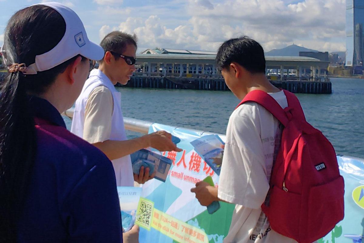 警方與民航處到中西區海濱長廊中環段一帶,向市民派發有關小型無人機限飛區的宣傳單張。(警方FB)