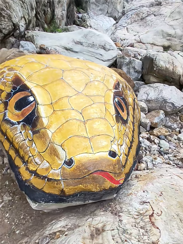 巨石原本是天然原石,景區後來邀請專人將其彩繪成「黃金蟒蛇頭」造型。