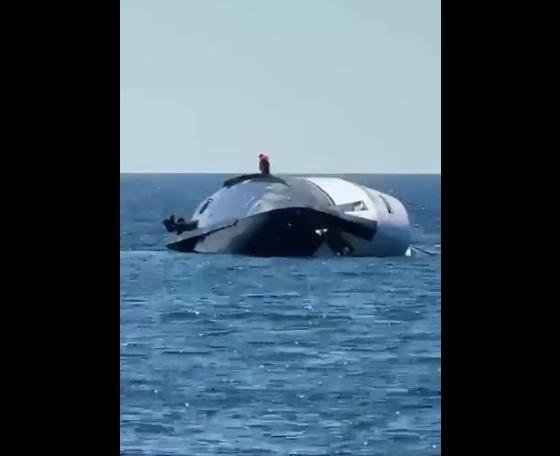 豪華遊艇打橫瞓在海上,有人走上船身。(互聯網)