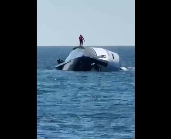 豪華遊艇打橫瞓在海上,有人走上船身查看。(互聯網)