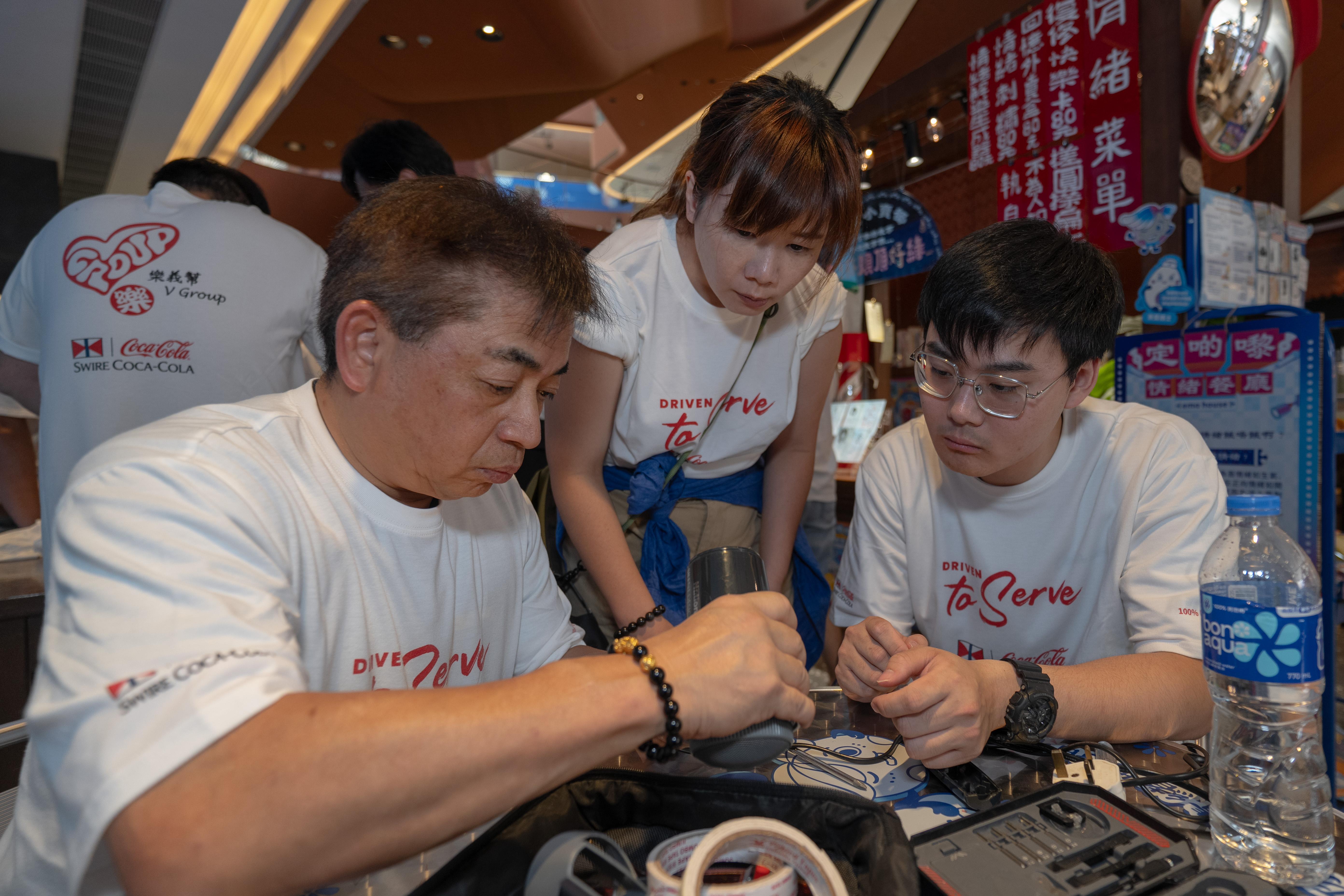 十多名香港太古可口可樂外勤電子機械技術員在活動中擔任義工,為街坊修理家電。