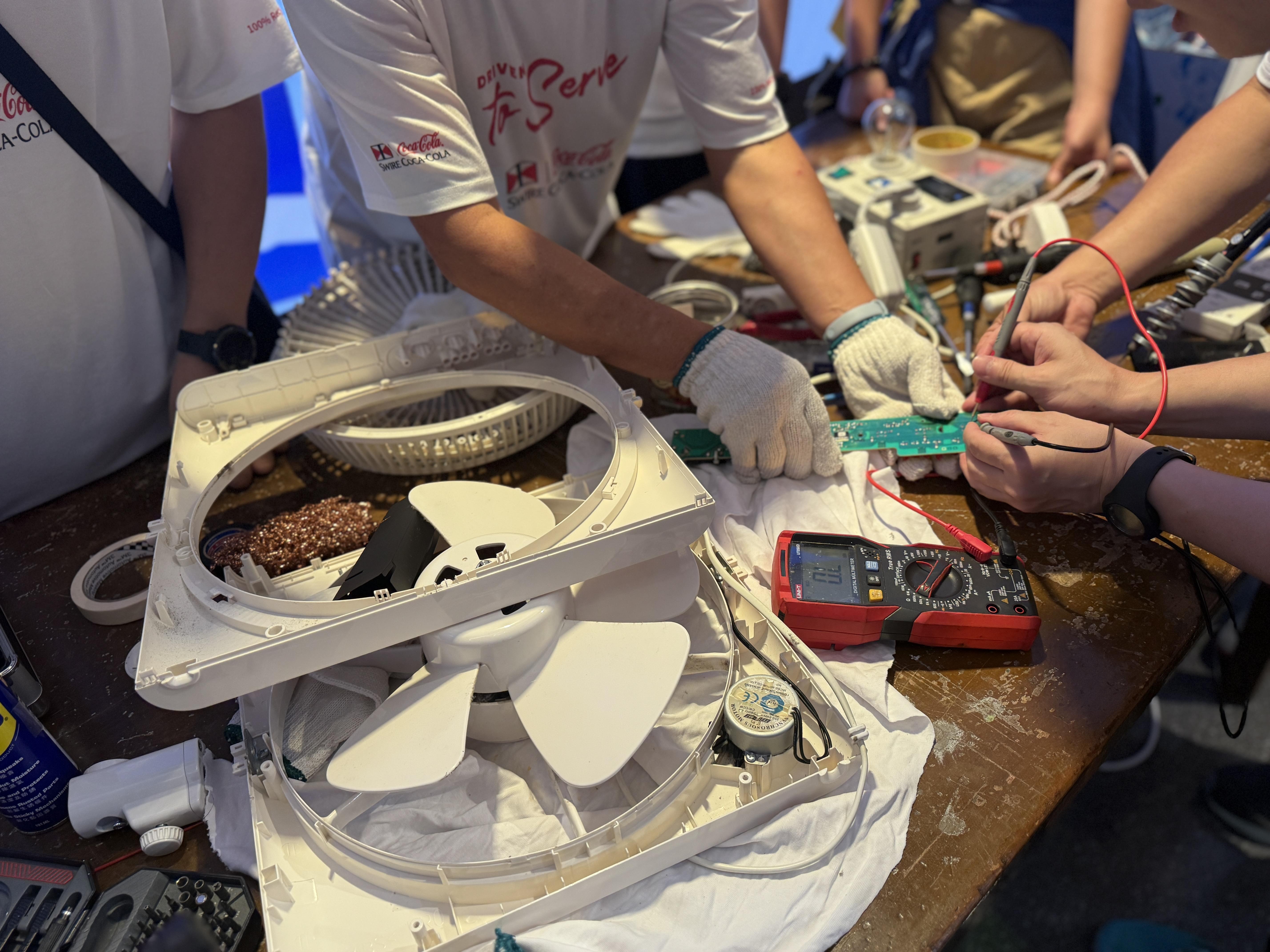 太古可口可樂十多名義工整個下午無間斷地又拆又裝,為身患不同「奇難雜症」的小家電進行檢查及維修。