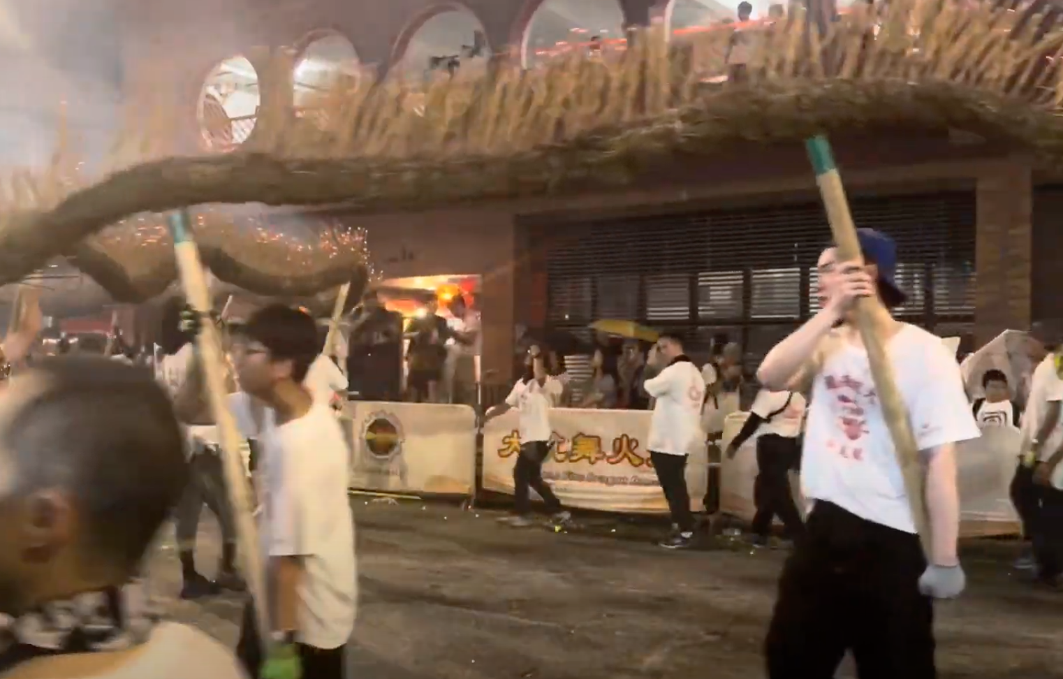洪助昇(右)有份舞火龍,雖然鏡頭不太清楚,但因為只得他一人戴藍色帽去舞火龍,所以很易認到。