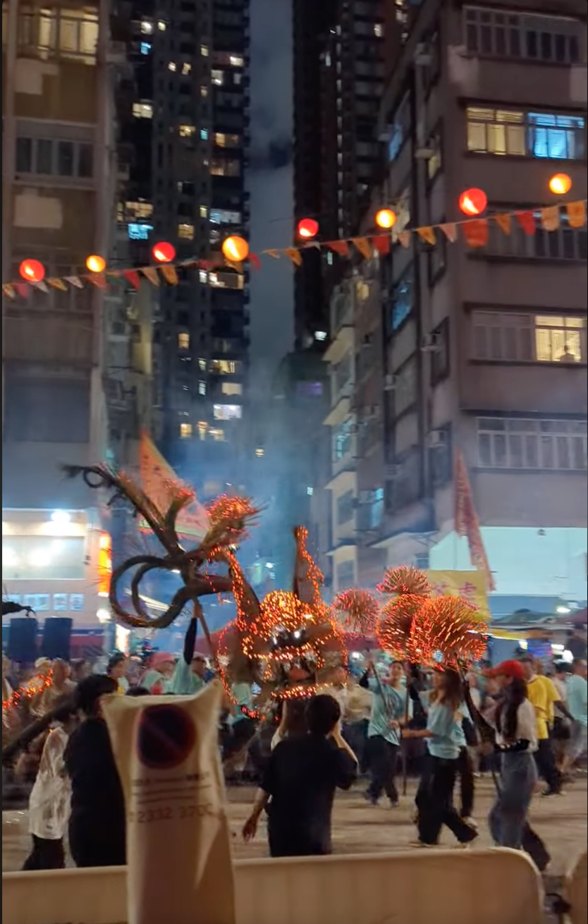 炎明熹戴住紅色帽舞動LED燈龍珠。