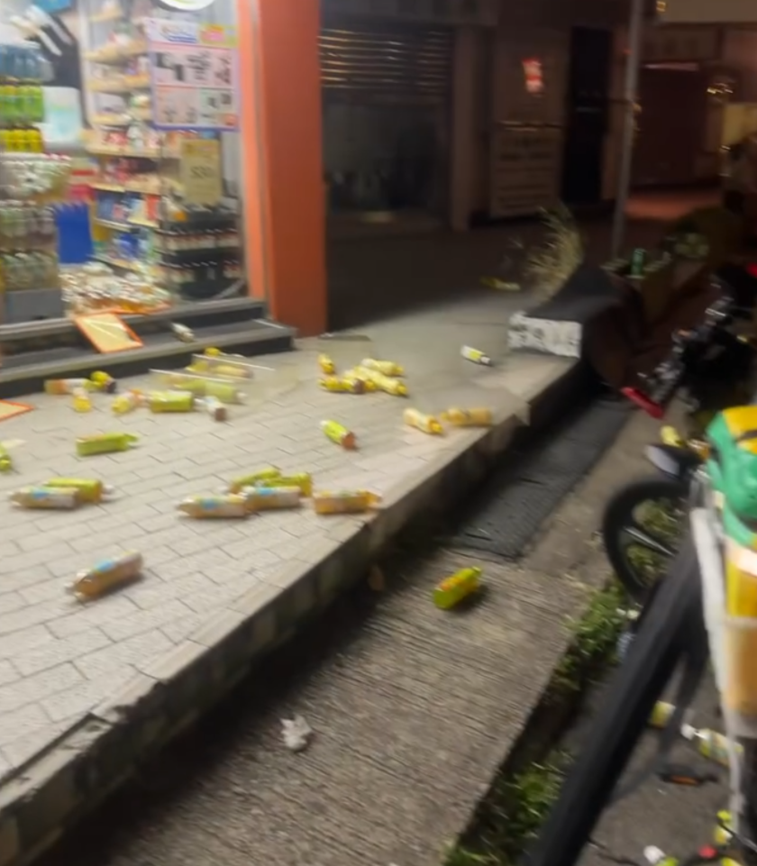 大圍田心街一間7-11便利店的職員報案,指一名年約30歲男子打爆店內的凍櫃玻璃門,並掃毀放於門口的飲品後,及後逃去無蹤。片段可見,事發後大量樽裝飲品四散一地,跌出行人路和單車徑。(Threads@mxrcuz 影片截圖)