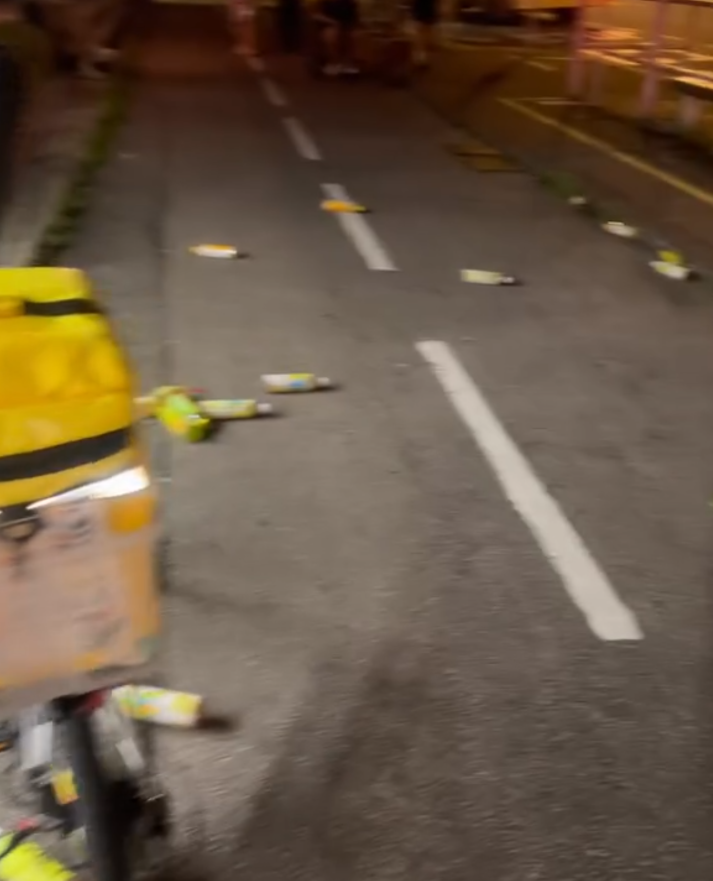 大圍田心街一間7-11便利店的職員報案,指一名年約30歲男子打爆店內的凍櫃玻璃門,並掃毀放於門口的飲品後,及後逃去無蹤。片段可見,事發後大量樽裝飲品四散一地,跌出行人路和單車徑。(Threads@mxrcuz 影片截圖)