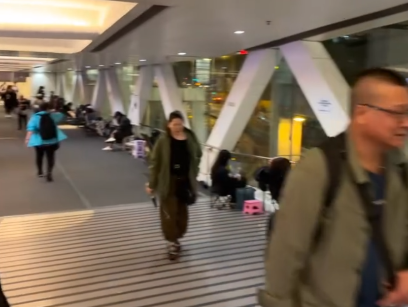 觀塘apm商場附近的天橋上度出現奇怪人龍,不少人更自備露營椅「長期作戰」,引發網上熱議。(Threads影片截圖)