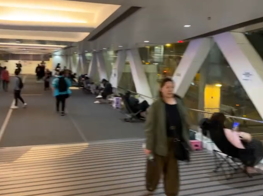 觀塘apm商場附近的天橋上度出現奇怪人龍,不少人更自備露營椅「長期作戰」,引發網上熱議。(Threads影片截圖)