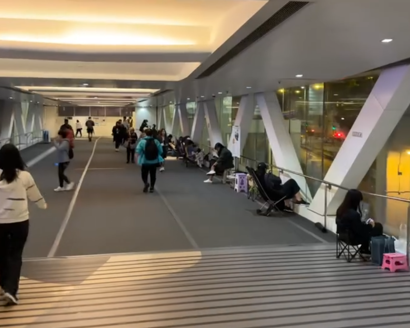 觀塘apm商場附近的天橋上度出現奇怪人龍,不少人更自備露營椅「長期作戰」,引發網上熱議。(Threads影片截圖)