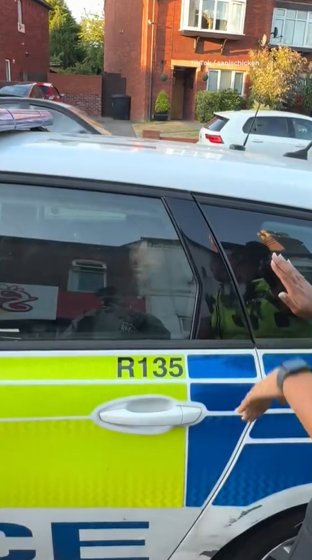 另一女警則質問一名男子為何他賣的炸雞那麼好吃,男子不答後她隨即關上警車門,將他困住。(互聯網)