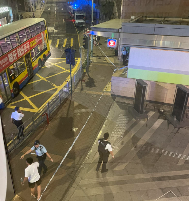 警方接獲一名男子報案指於西區屈地街近香港大學站B1出囗外,被一名男子用刀刺傷腰部,施襲者逃去。現場照片可見地面遺下一灘血漬,警方封鎖現場調查事件,有警員帶同警犬戒備。(西環變幻時FB)