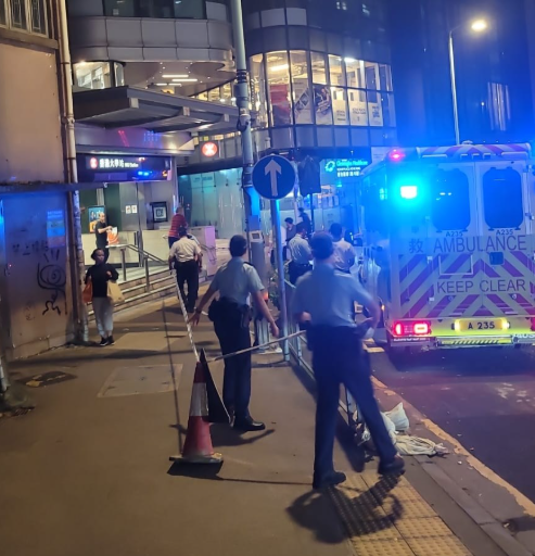 警方接獲一名男子報案指於西區屈地街近香港大學站B1出囗外,被一名男子用刀刺傷腰部,施襲者逃去。現場照片可見地面遺下一灘血漬,警方封鎖現場調查事件,有警員帶同警犬戒備。(西環變幻時FB)