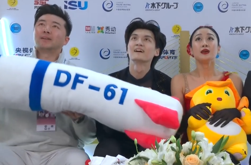 中國盃花樣滑冰大獎賽冰舞賽上周六(25日)於重慶舉行,賽後中國組合任俊霏、邢珈寧在等候分區成績期間,一度拿起觀眾拋入場內、標有「DF-61」字樣的東風61型導彈造型毛絨公仔,並做出模擬飛行動作(影片截圖)