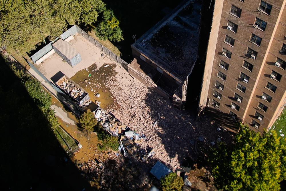 大廈其中一邊煙囪連牆身整幅倒塌,瓦礫散落地面,現場塵土飛揚。(AP)