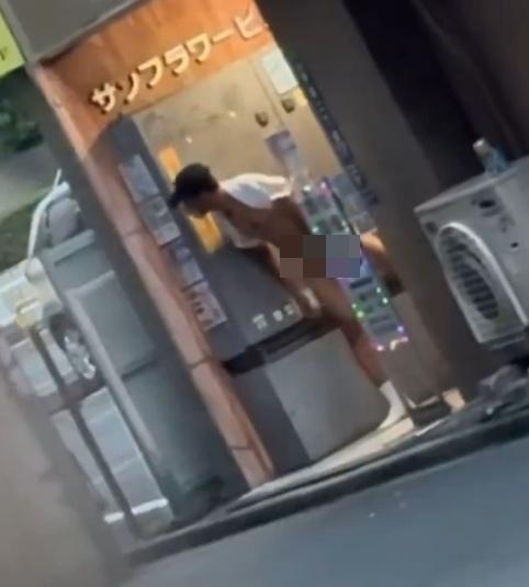 草間在新宿區一棟大樓的出入口附近,露出下半身,引首左顧右盼。(X)