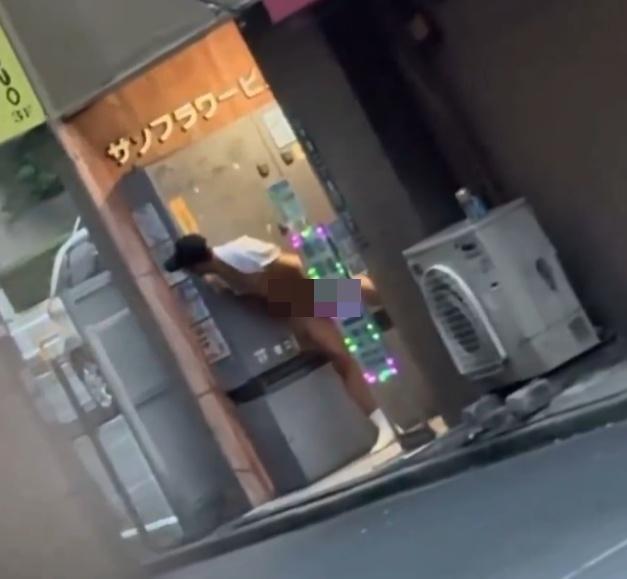 草間在新宿區一棟大樓的出入口附近,露出下半身,引首左顧右盼。(X)