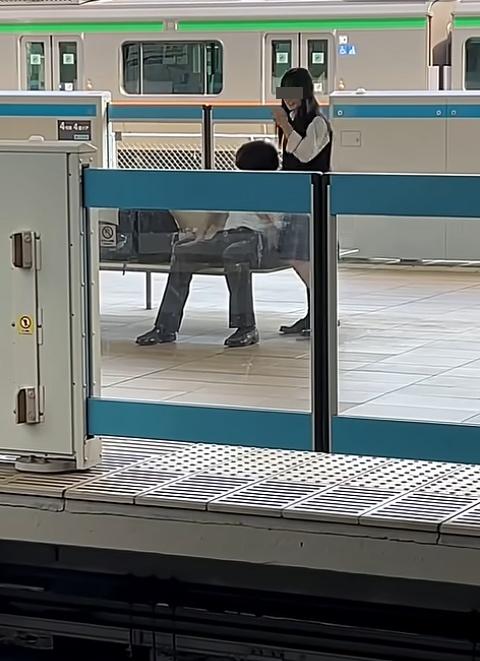 女生站身整理衣物與頭髮,稍為露出正臉,男方則低頭疑似滑手機,反應若無其事。(X)