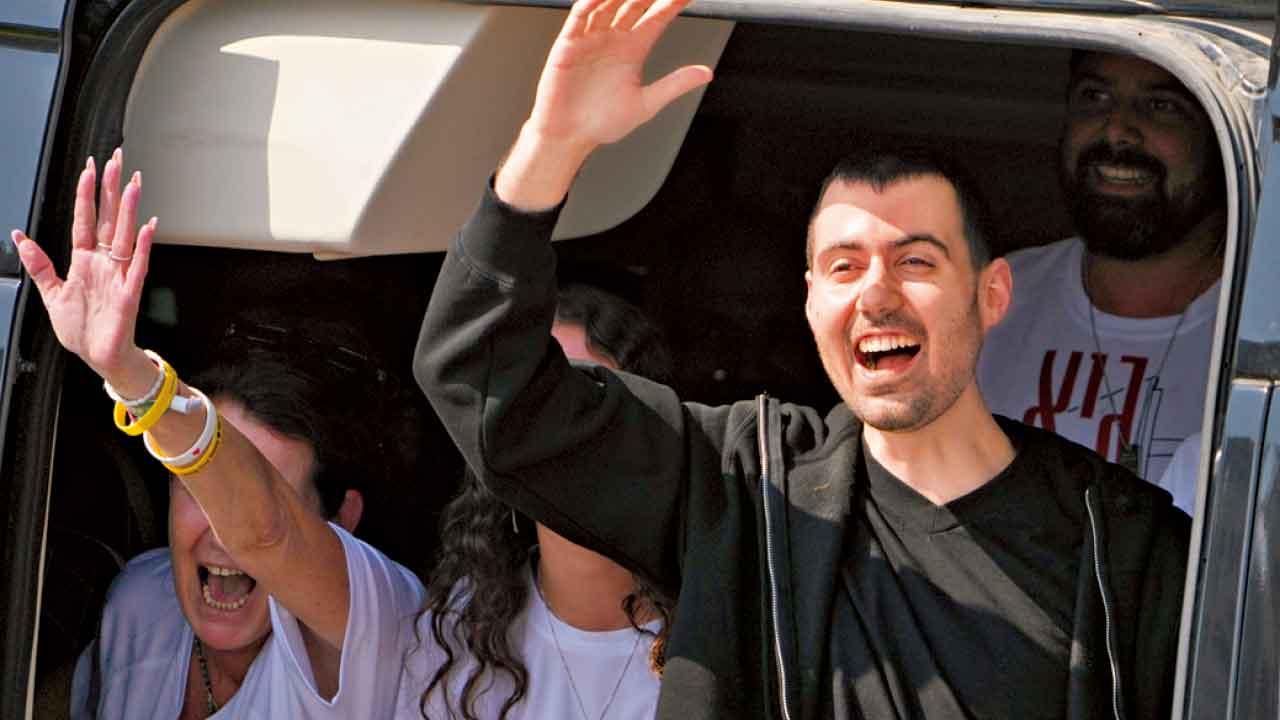 以色列人質獲釋後向傳媒揮手。(美聯社)