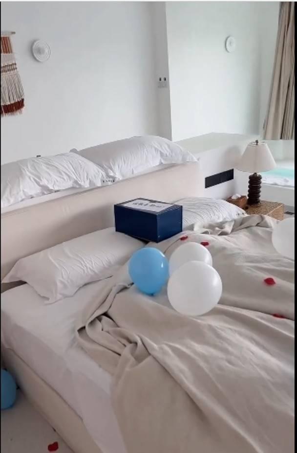 房內king size大床,上面放滿藍色和白色的氣球。