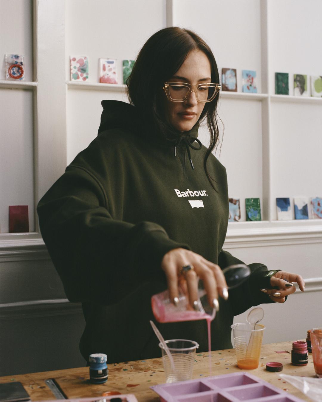 松柏綠連帽衛衣,其聯乘圖案把Barbour經典燈塔標誌與Levi's雙馬拉車標識合而為一。