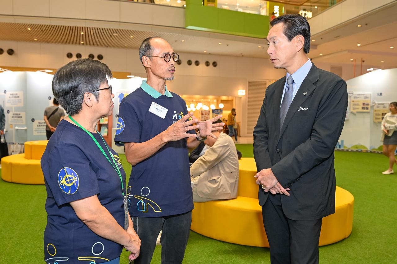 陳智思(右)與其他嘉賓參觀有關「賽馬會樂載耆蹤社區長者支援計劃」的展覽。