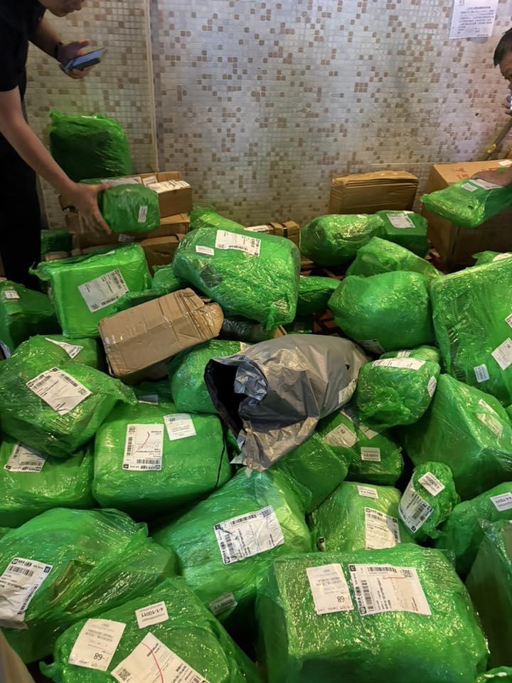屯門龍門居地下一間自提點外堆滿數以百計、來自拼多多的綠色包裹,形成一片「綠色海洋」,大批街坊下班後在自提點外自行「尋寶」,場面混亂。(龍門居消息交流FB)