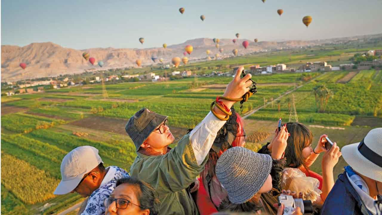 華人遊客在埃及樂蜀一嘗乘坐熱氣球滋味。(美聯社)